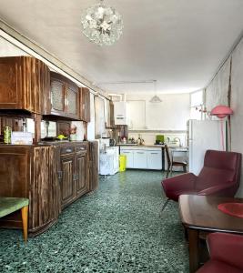 a kitchen with wooden cabinets and a red couch in it at Villa Coccodrilla Varallese in Varallo