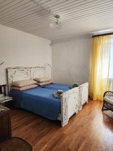 a bedroom with a large bed with a blue sheet at Villa Coccodrilla Varallese in Varallo
