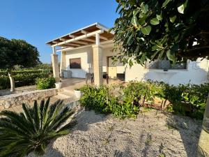 a white house with a porch and some plants at AgriFamily Village in San Vito dei Normanni