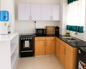 a kitchen with white cabinets and a black stove at kijani retreat in Nairobi