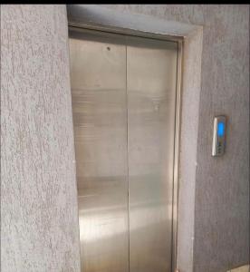 a metal elevator door with a blue light on it at kijani retreat in Nairobi