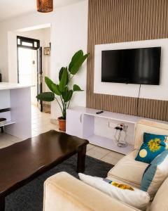 a living room with a couch and a tv on a wall at kijani retreat in Nairobi
