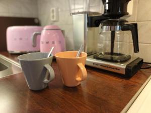 two cups sitting on a counter next to a coffee maker at Koivukuja Apartment in Vuokatti +10 photos