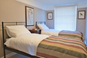 two beds in a bedroom with a window at Gosse House in Deal