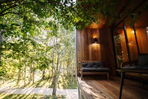 a tree house with a large glass door leading to a porch at The Grit - Adults-Only Modern Design House near Brașov in Vama Buzăului