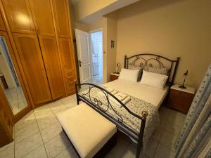 a bedroom with a bed and a bench in it at Christina's Apartments in Vathi
