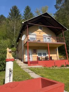 a house with a teddy bear in front of it at Vikendica Markić in Šipovo