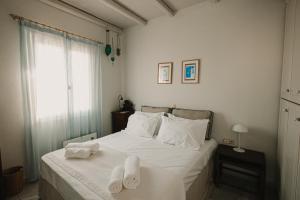 a bedroom with a bed with towels on it at Dinora Stone Villa, Pool & Sea Views in Tinos in Agios Ioannis +59 photos