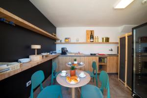 a dining room with a table and blue chairs at Alternative Resort & SPA in Scorrano