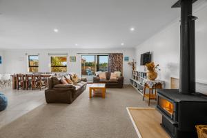a living room with a couch and a fireplace at Waterfront location with estuary outlook and ocean beach access - sleeps 19 in Pukehina