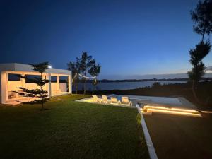 a house with a yard with two white chairs at Dzixile in Gueima