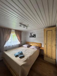 a bedroom with a large bed with a ceiling at Sadyba Geredzhuka in Vorokhta