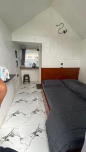 a bedroom with a bed and a marble floor at Villa Miradarma in Sembalun Lawang