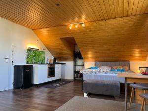 a large room with a bed and a wooden ceiling at Wesernest Schulz in Höxter