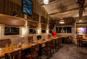 a restaurant with wooden tables and chairs in a room at Hillary Hotel in Les Menuires