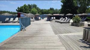 a deck with lounge chairs and a swimming pool at Mobil home zen élégant in Mimizan