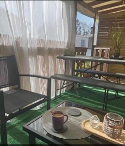 a cup of coffee sitting on a table on a patio at Mobil home zen élégant in Mimizan