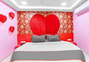 a bedroom with a large red heart on the wall at HOTEL Sarovar in Ahmedabad +16 photos