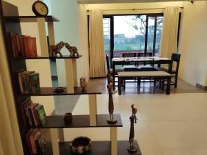 a living room with a clock on the wall and a table at Bhromor -A Pet-friendly Villa in Raichak +30 photos