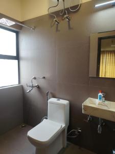 a bathroom with a toilet and a sink and a mirror at Bhromor -A Pet-friendly Villa in Raichak