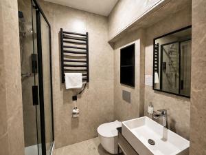 a bathroom with a white sink and a toilet at Prime Hotel in Dnipro