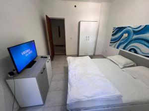 a bedroom with a bed and a television on a desk at LaScena in Techirghiol