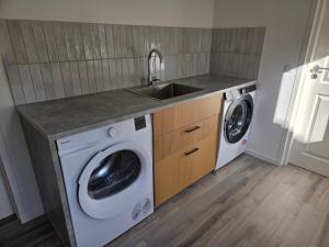 a kitchen with a sink and a washing machine at Harknakvej 19BB in Bredebro