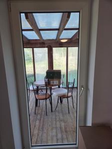 a glass door leading to a deck with a table and chairs at Harknakvej 19BB in Bredebro