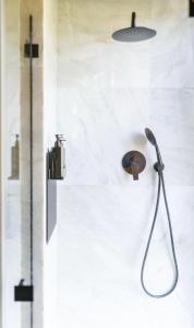 a shower with a shower head on a wall at The Grit - Adults-Only Modern Design House near Brașov in Vama Buzăului +19 photos