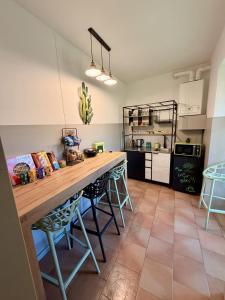 a kitchen with a large wooden counter with stools at Porta Del Ricetto in Candelo