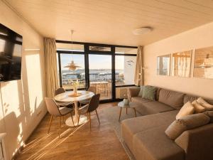 a living room with a couch and a table at Meerblick in der Meerzeitliebe Fehmarn in Fehmarn