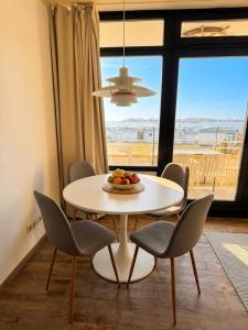 a table with chairs and a bowl of fruit on it at Meerblick in der Meerzeitliebe Fehmarn in Fehmarn