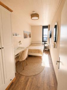 a bedroom with a bed and a table and a window at Meerblick in der Meerzeitliebe Fehmarn in Fehmarn