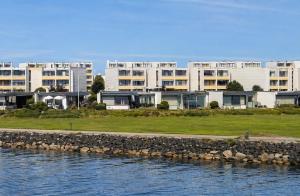 a row of apartment buildings next to a body of water at Meerblick in der Meerzeitliebe Fehmarn in Fehmarn