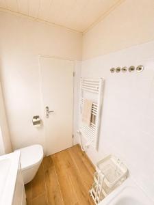 a white bathroom with a toilet and a sink at Meerblick in der Meerzeitliebe Fehmarn in Fehmarn +33 photos