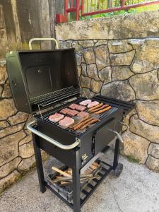 a grill with a bunch of hot dogs on it at Vikendica Markić in Šipovo