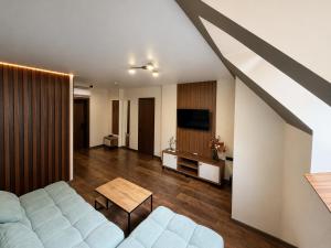 a living room with a couch and a tv at Prime Hotel in Dnipro