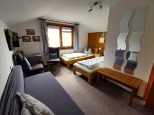 a living room with a bed and a couch and chairs at Pension Stepponat in Arnstadt