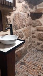 a stone bathroom with a sink and a stone wall at A casa da Cernada in Rocas +37 photos