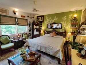 a bedroom with a bed and a chair and a table at On the House homestay in New Delhi +74 photos