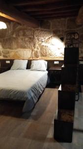 a bedroom with a bed in a stone wall at A casa da Cernada in Rocas