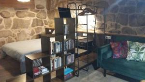 a book shelf filled with books next to a couch at A casa da Cernada in Rocas