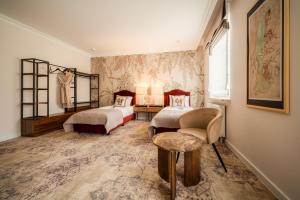 a bedroom with two beds and a table and a chair at Piotrkowska 89 Residence in Łódź +120 photos