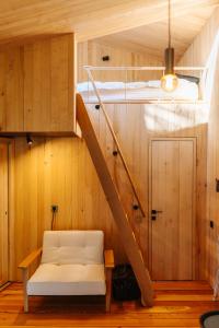 a room with a white couch and a staircase at The Grit - Adults-Only Modern Design House near Brașov in Vama Buzăului