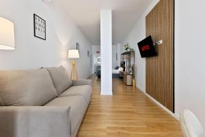 a living room with a couch and a tv on a wall at Pato - Modern Apt - Near Bioparc by Río Turia Apartments in Valencia