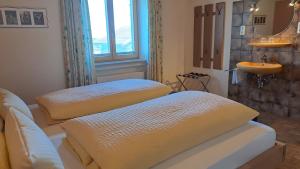 two beds in a room with a sink and a mirror at Ferienwohnung Hörnle Bad Kohlgrub in Bad Kohlgrub