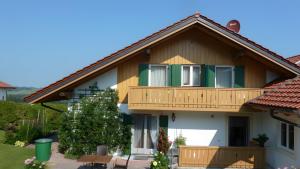 a house with a balcony and a christmas tree at Ferienwohnung Hörnle Bad Kohlgrub in Bad Kohlgrub