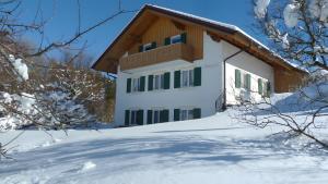 a house in the snow with snow covered trees at Ferienwohnung Hörnle Bad Kohlgrub in Bad Kohlgrub