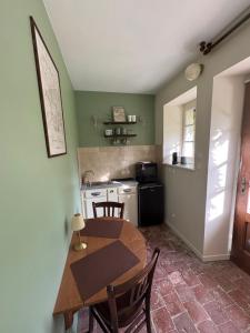 a kitchen with a wooden table and a table and chairs at La Roseraie de Malpas in Quingey