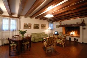 ヴィゴンツァにあるAgriturismo Villa Selvaticoのリビングルーム(暖炉、テーブル、椅子付)